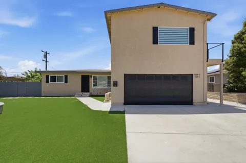 Residential exterior with tan stucco and black shutters