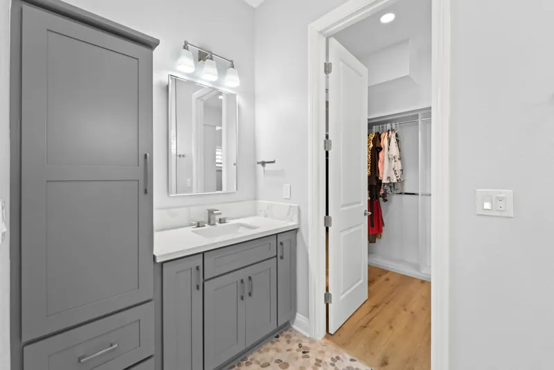Bathroom vanity beside a walk-in closet